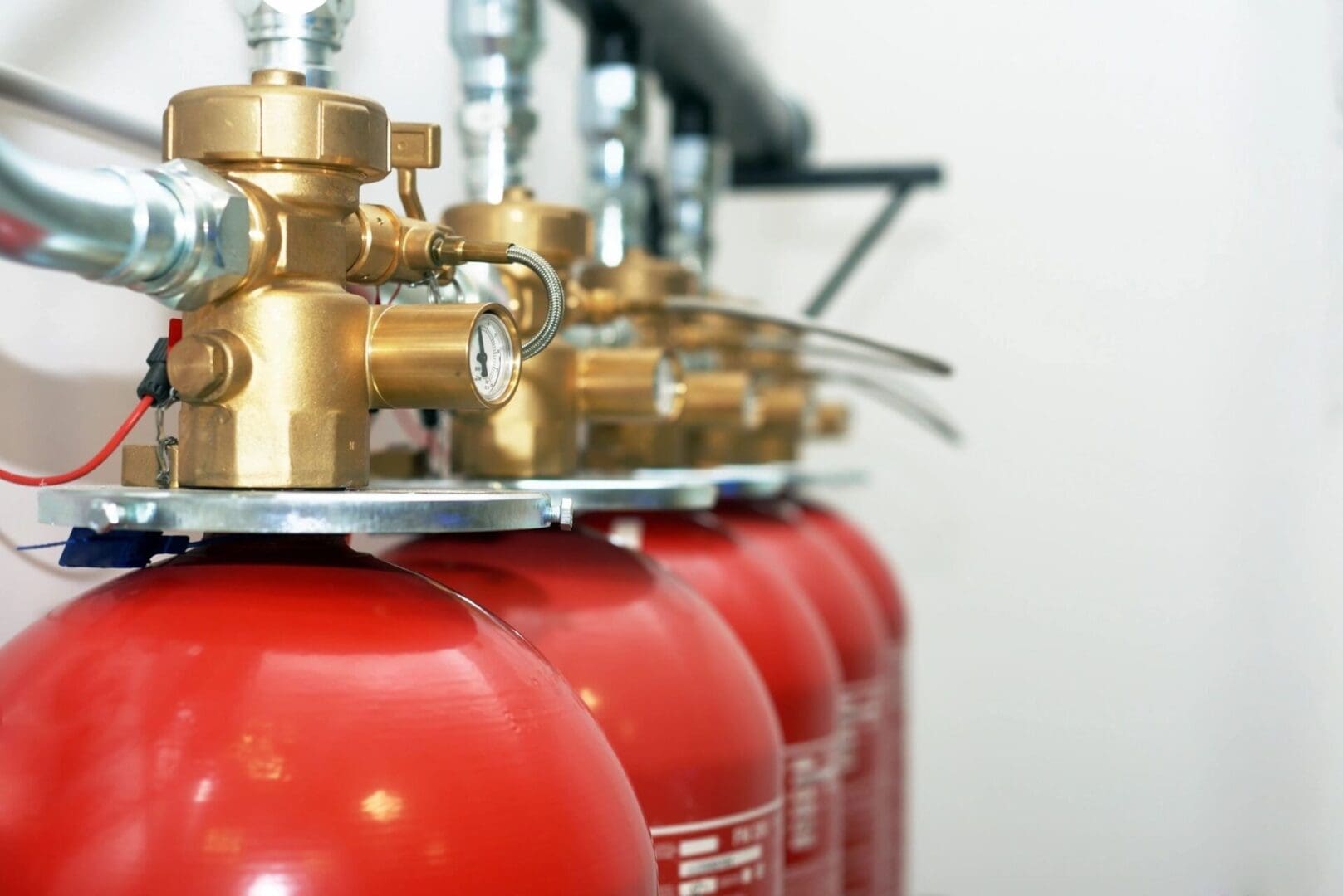 A group of red cylinders with valves on them.
