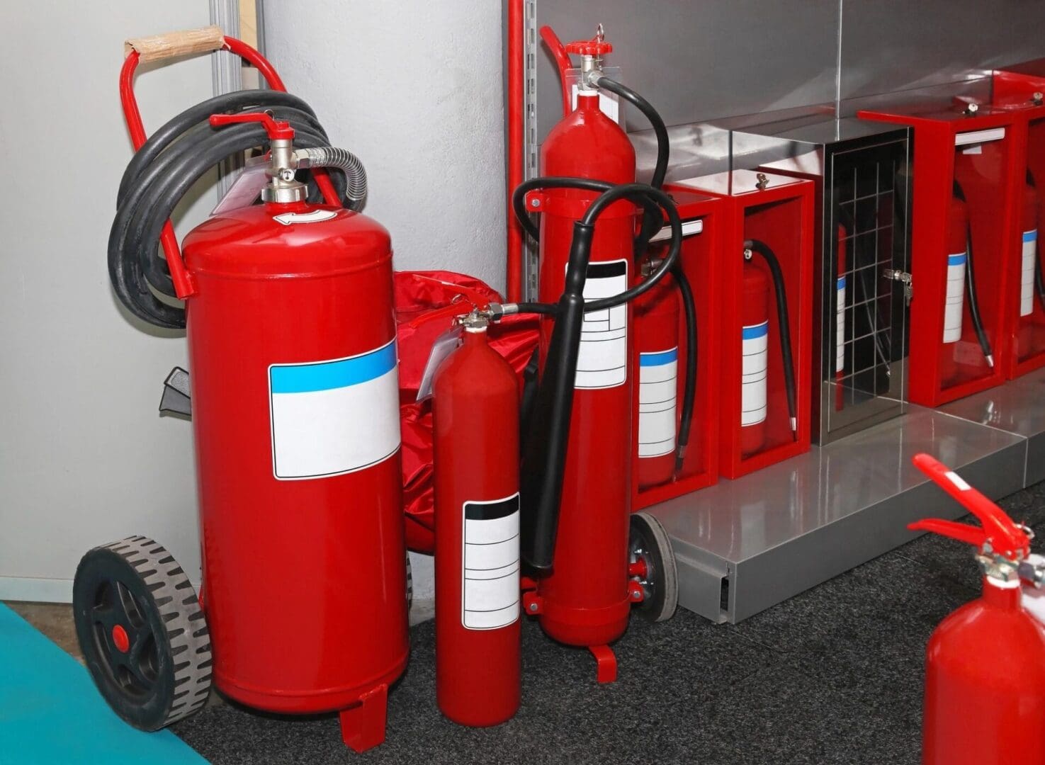 A group of red fire extinguishers sitting next to each other.