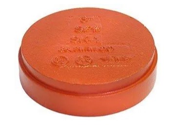 Orange plastic round cover with markings.